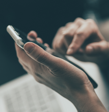 image of a person's hands holding a phone, about to type out something